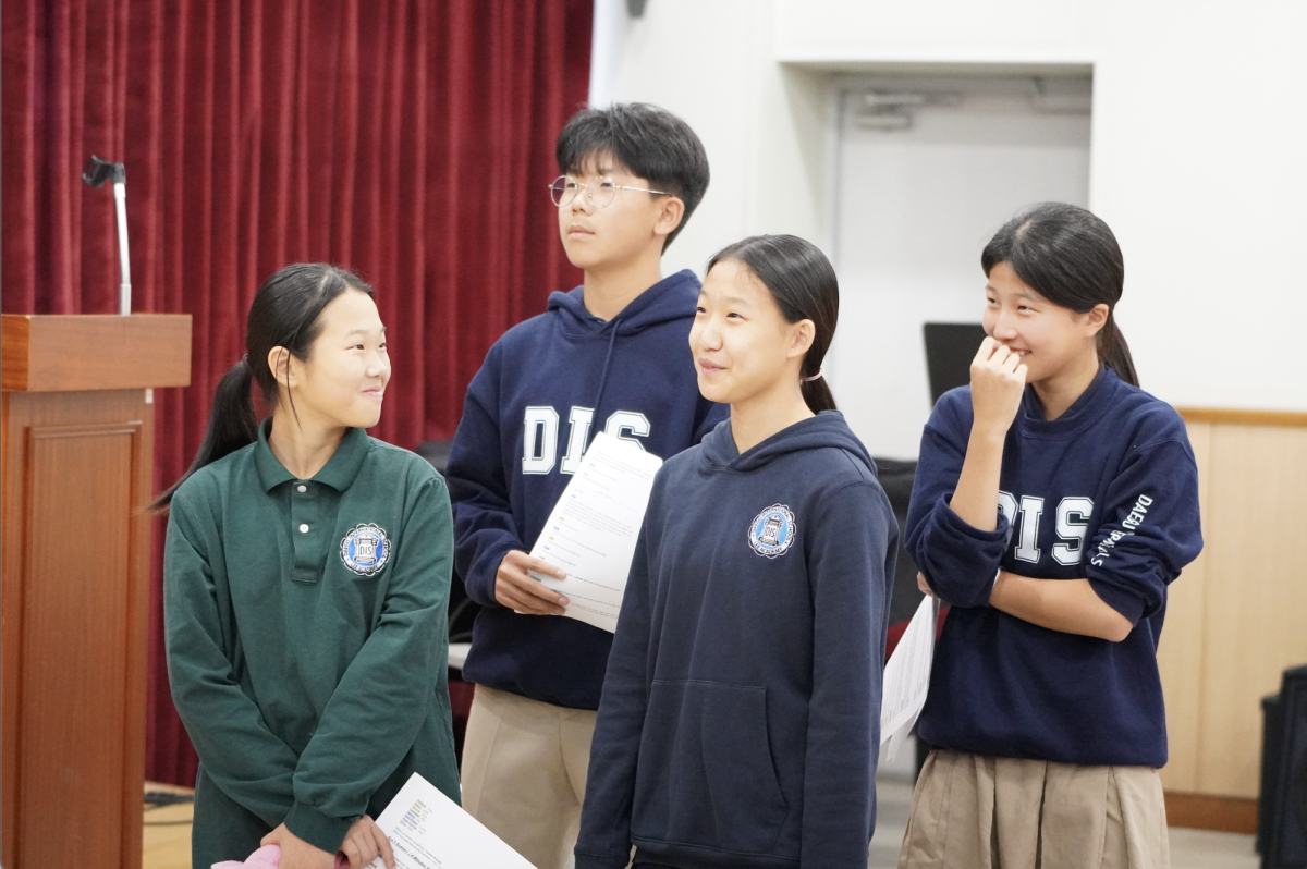 A group of seventh-graders eagerly wait for their turn to step up onto the stage, exchanging silent giggles that are lost to the buzz of excitement in the room. Although they feel nervous to showcase their act, they can't help but snicker at their friends' performances. 